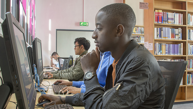 Three students working at computers in Wheatley Library.